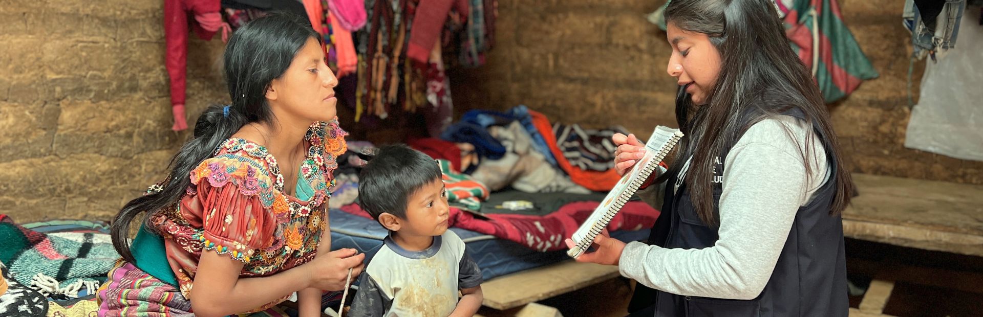 Family-Centered Nutrition Program Technician during a home visit with a patient and his mother