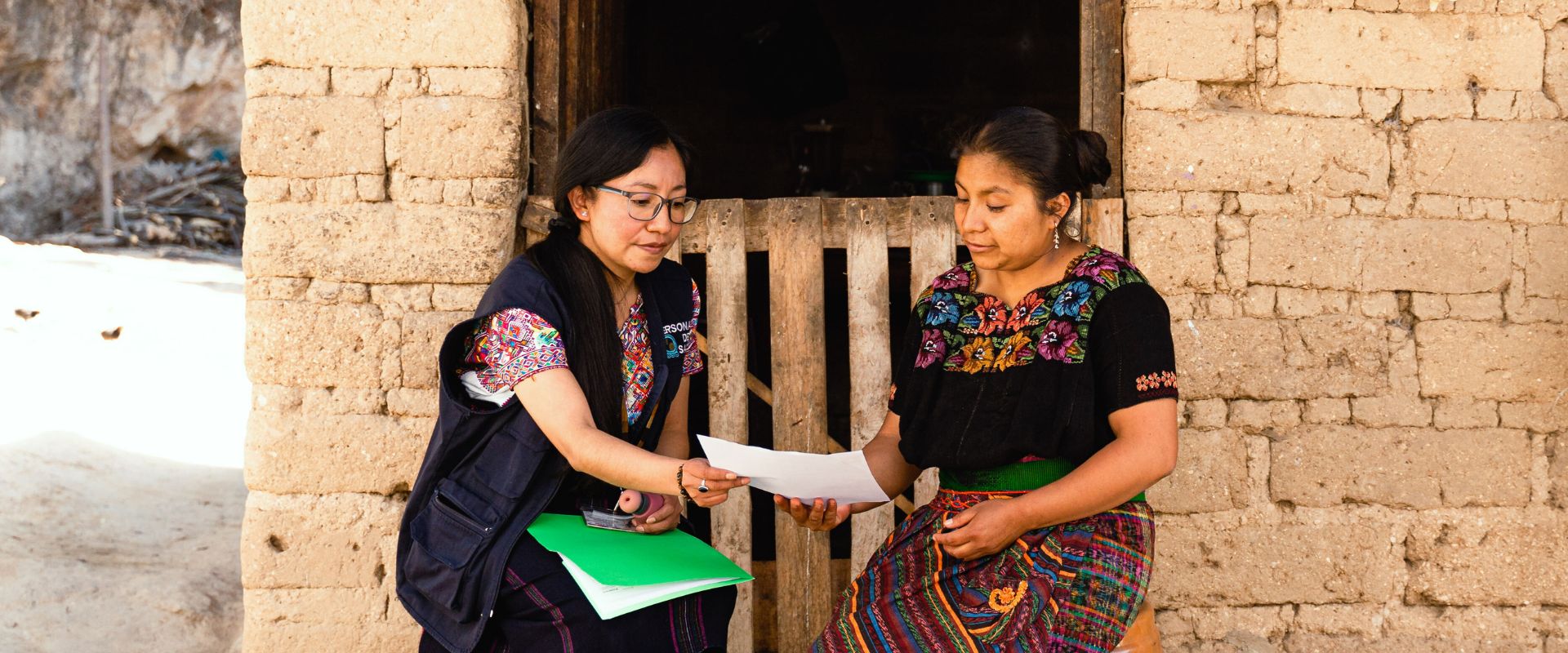 Gerente del Programa de Salud de la Mujer de Wuqu' Kawoq con una paciente durante una visita de campo